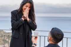 Man kneeling in front of his girlfriend during a wedding proposal Isola Bella