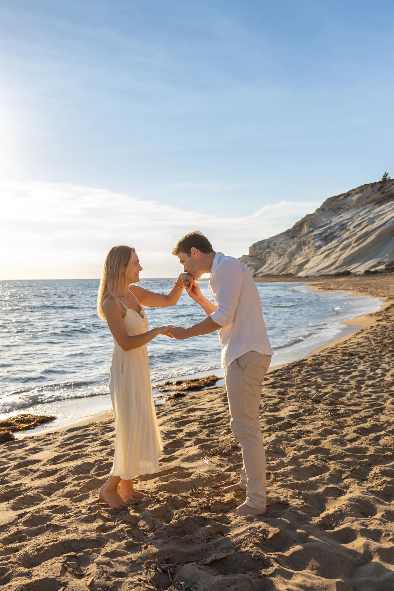 Romantic couple embrace by the sea at sunset in Sicily