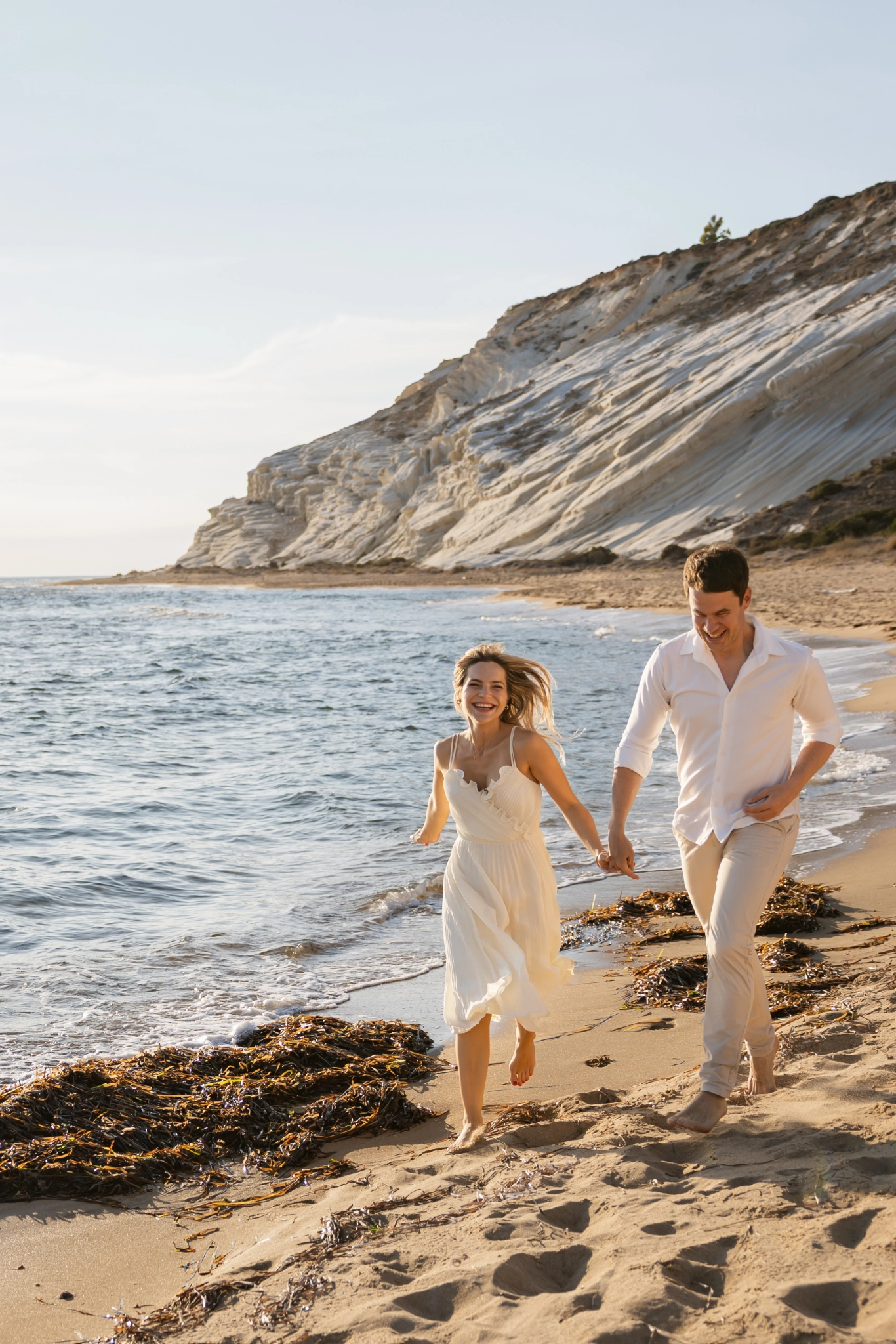 Couple running together in wild nature in Sicily after a proposal
